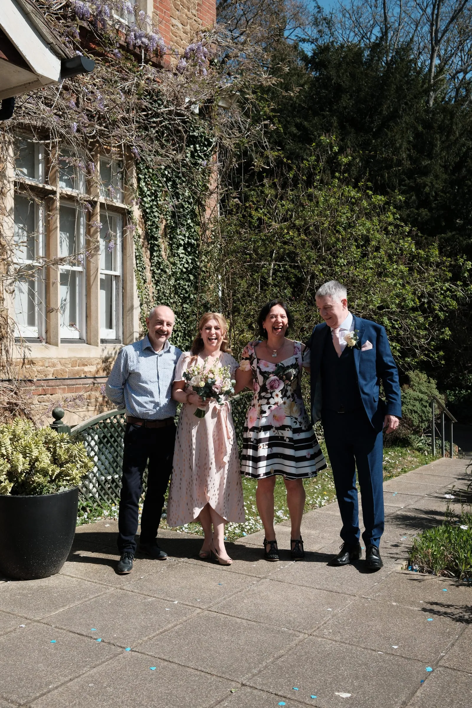 The couple with two guests in front of the house.