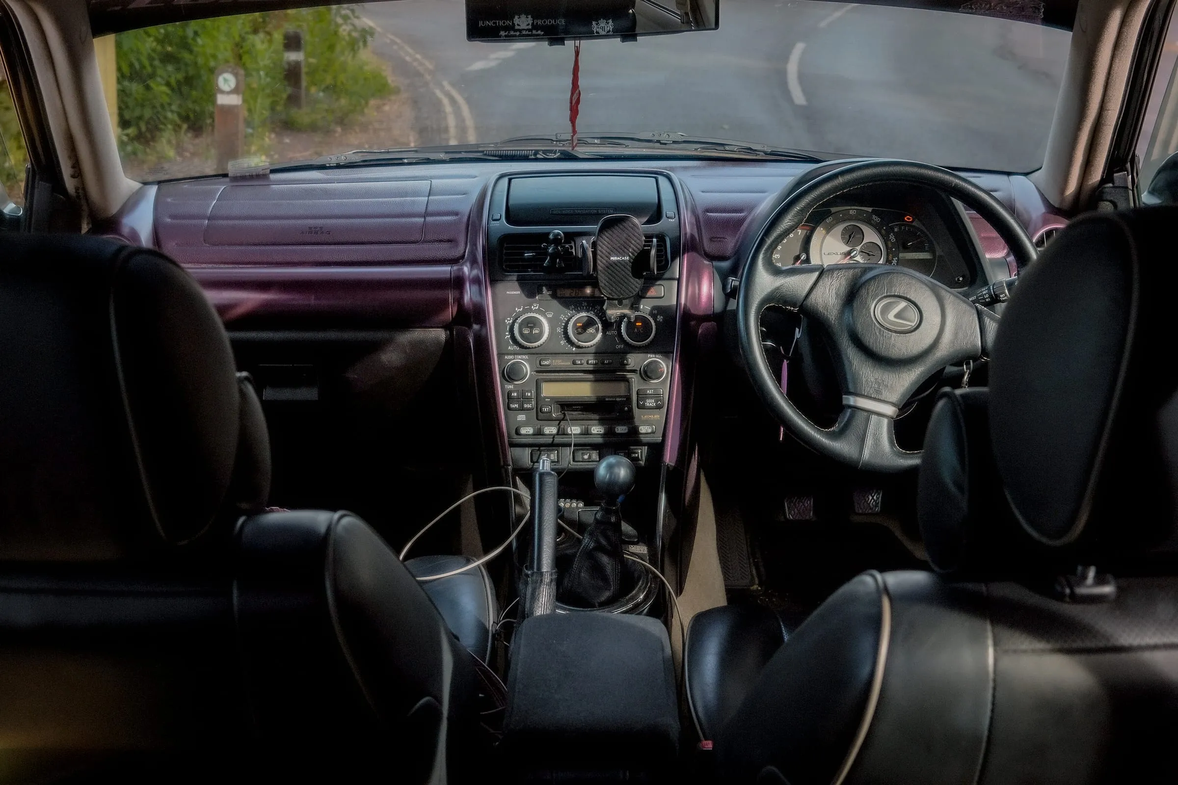 The interior from the back seat: purple dash trim, the steering wheel and the road ahead.