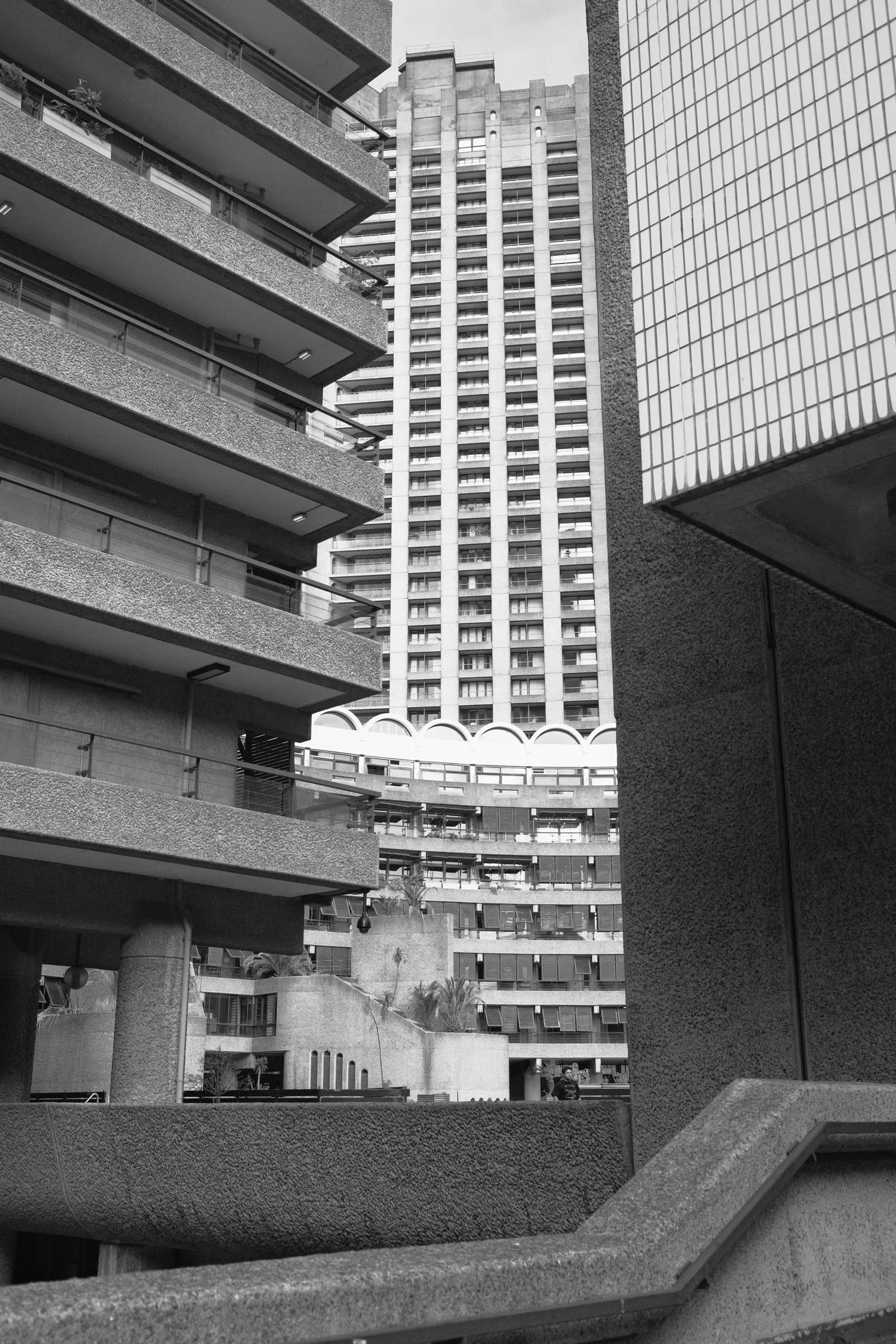 Concrete towers and balconies stacked against one another, in black and white.